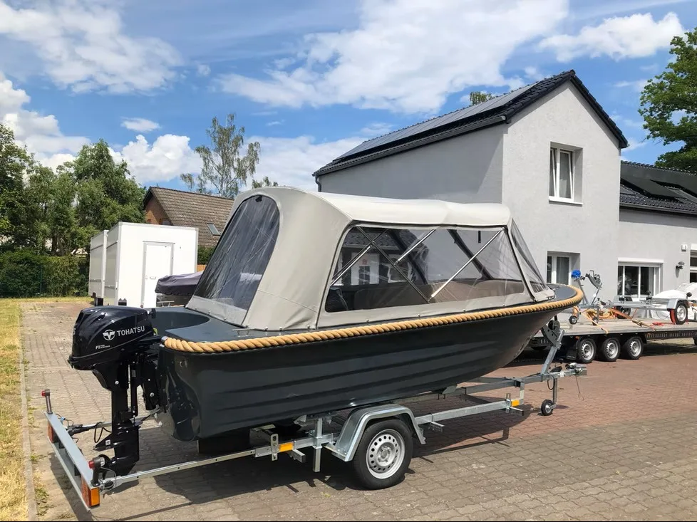 Schwarzes Motorboot auf einem Trailer mit hellgrauem transparentem Fahrverdeck.