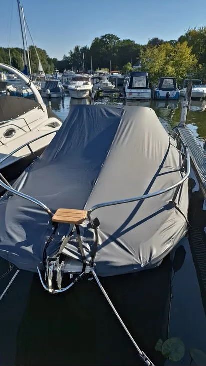 Boot am Wasser mit dunkelgrauer vollständig geschlossener Ganzabdeckung.