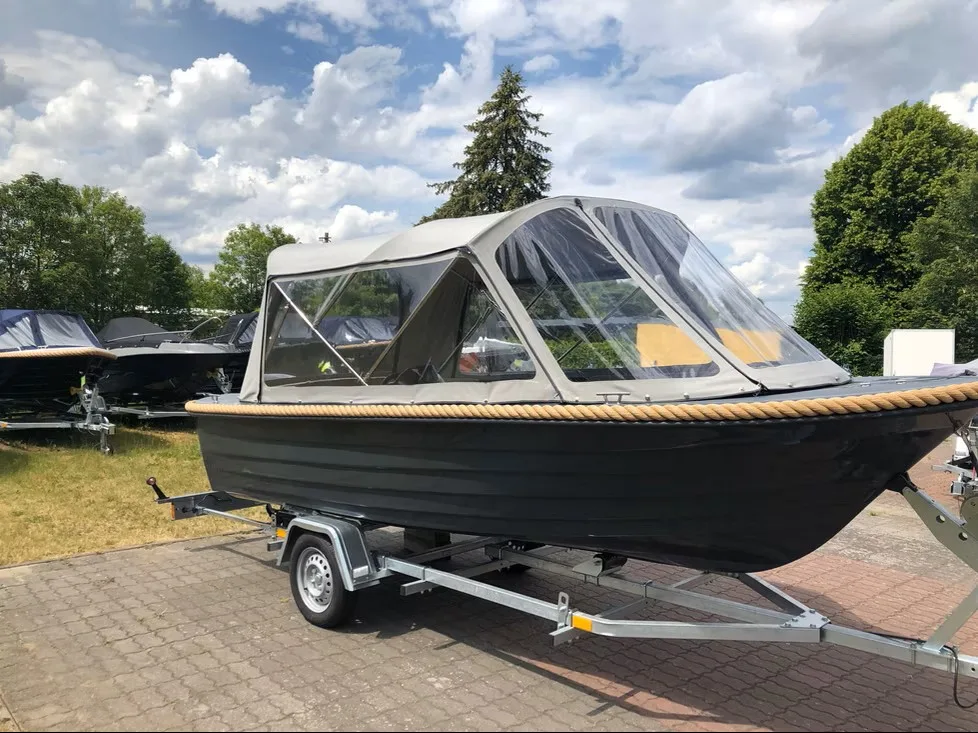 Schwarzes Motorboot auf einem Trailer mit hellem transparentem Fahrverdeck.