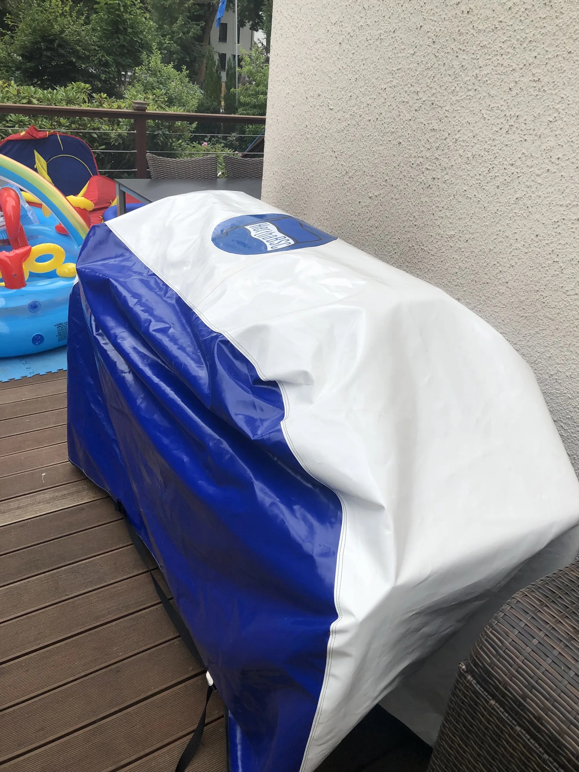 Blau-weiße Formabdeckung über einem länglichen Gegenstand im Außenbereich.