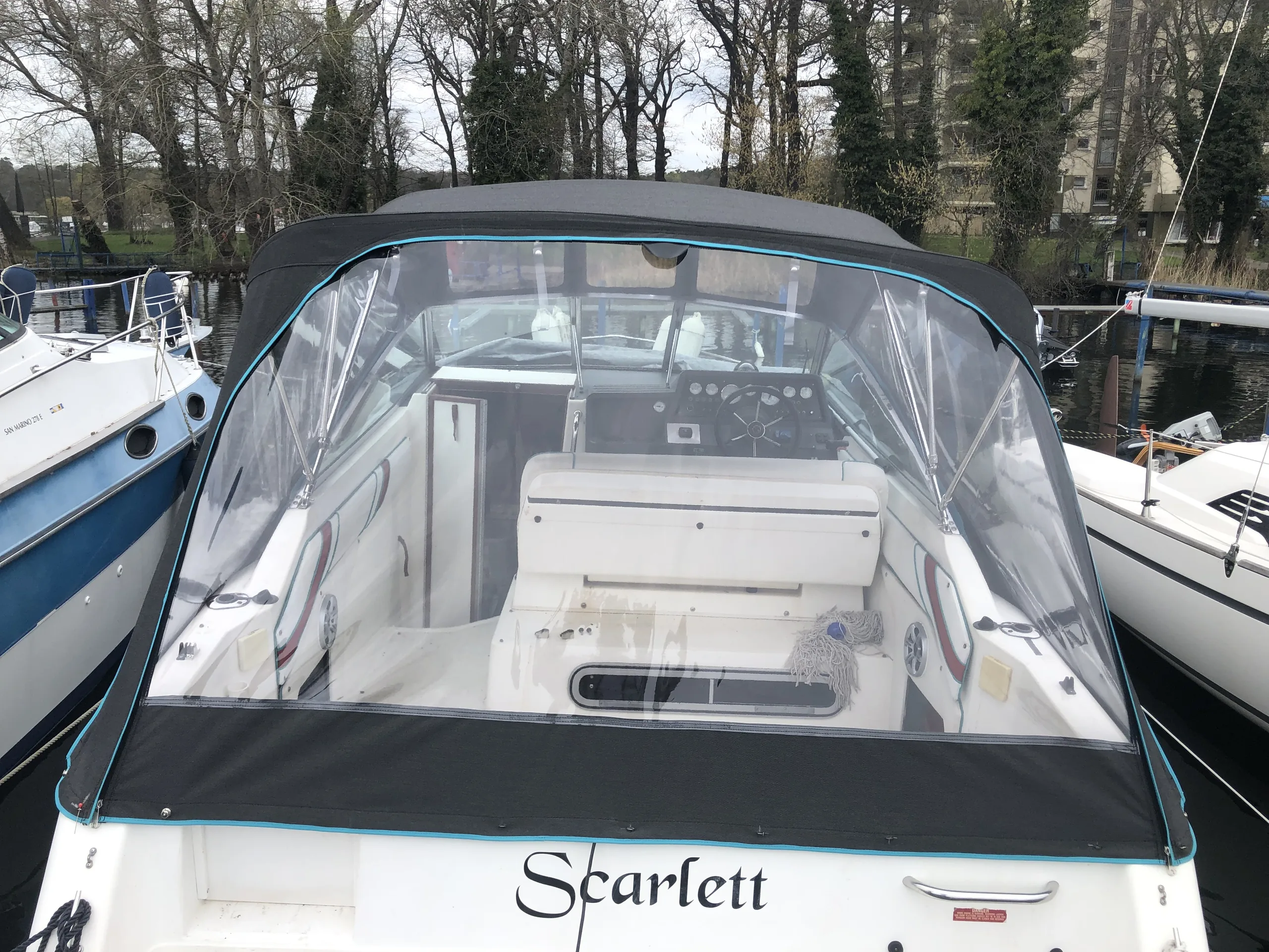 Fahrpersenning mit breitem transparentem Heckfenster auf einem weißen Motorboot.