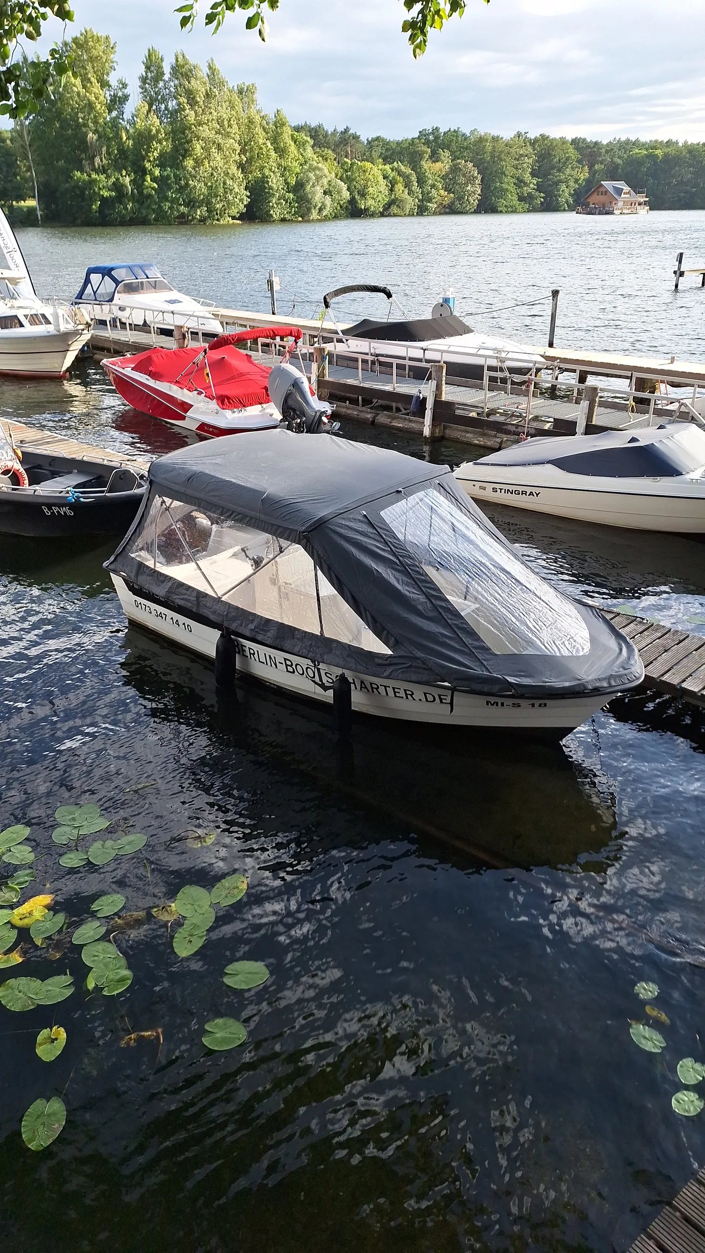 Motorboot mit geschlossener Fahrpersenning am Liegeplatz.