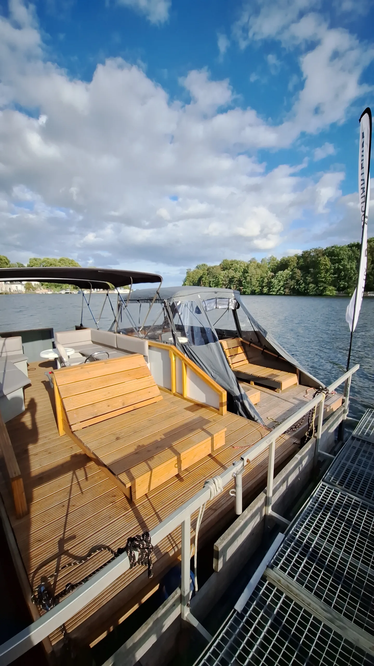 Geöffneter Cockpitbereich desselben Motorboots mit Bimini-Gestänge am Wasser.