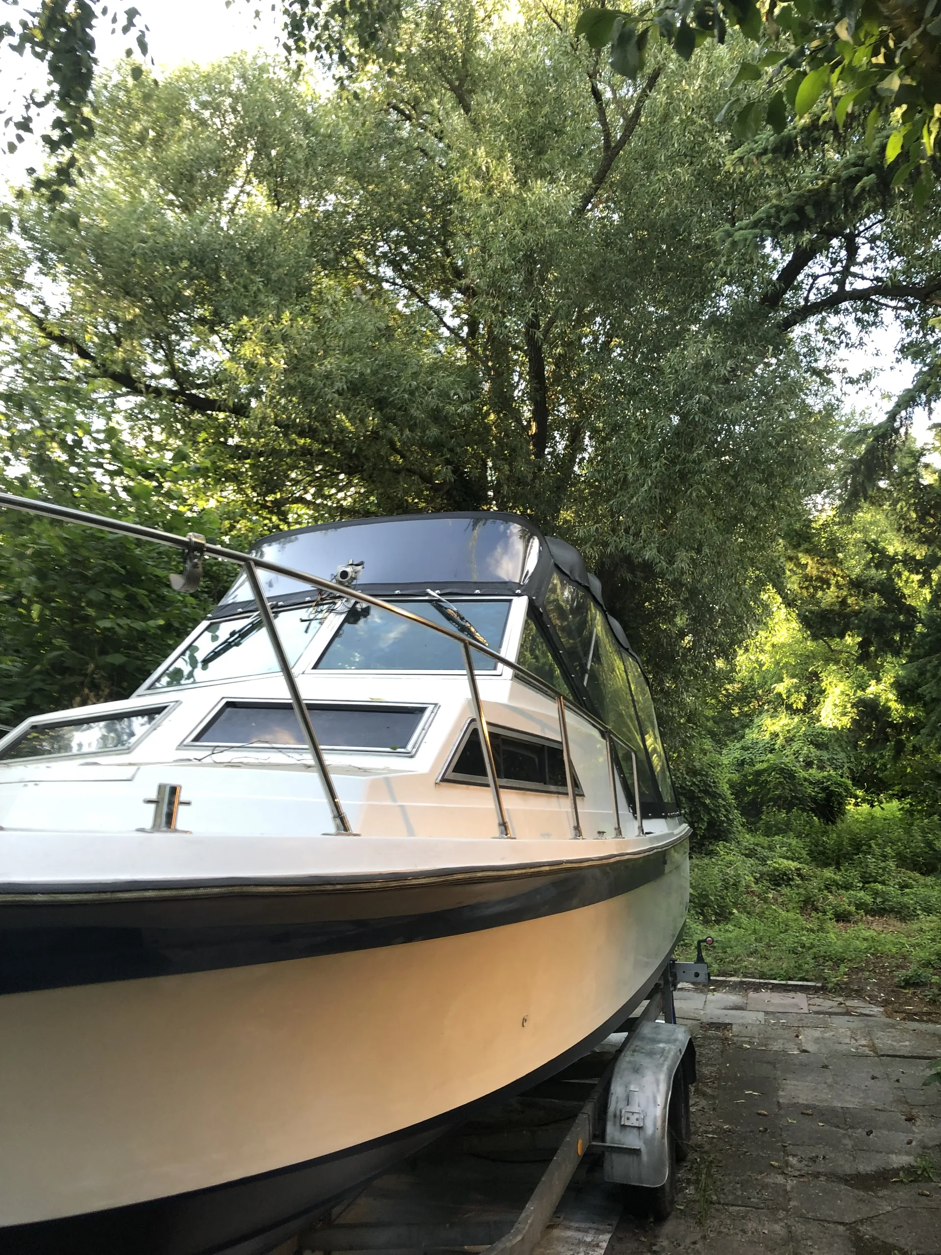 Kajütboot mit dunkler Fahrpersenning und seitlicher Fensterfläche.
