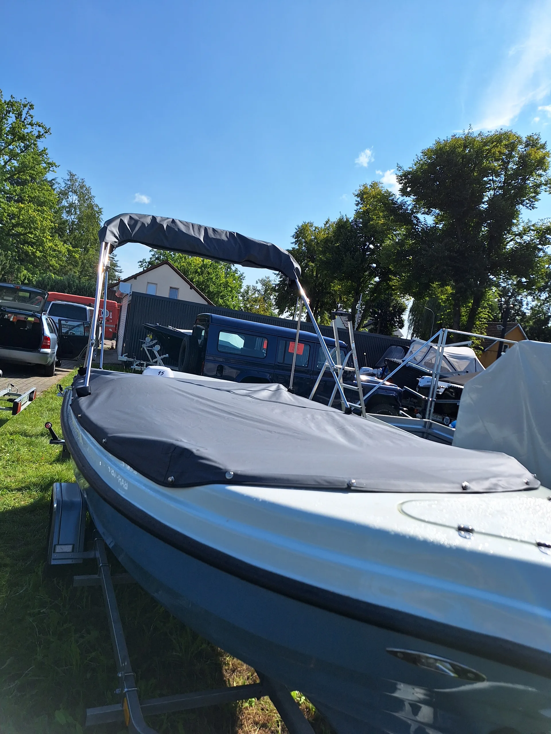 Motorboot mit dunklem Bimini und passender Abdeckung über dem Cockpit.