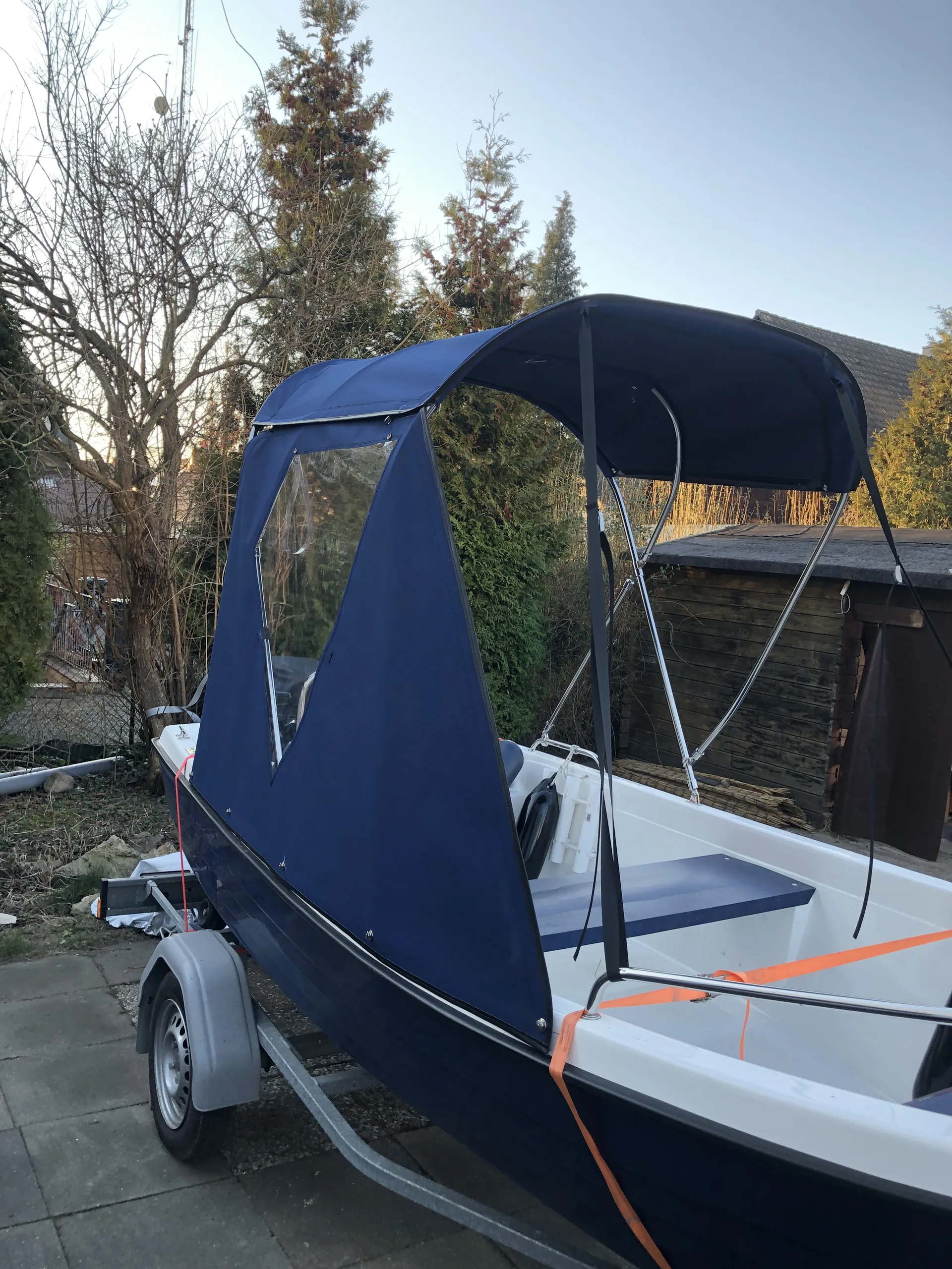Dunkelblaues Bimini mit transparenten seitlichen Schutzflächen auf einem Motorboot.