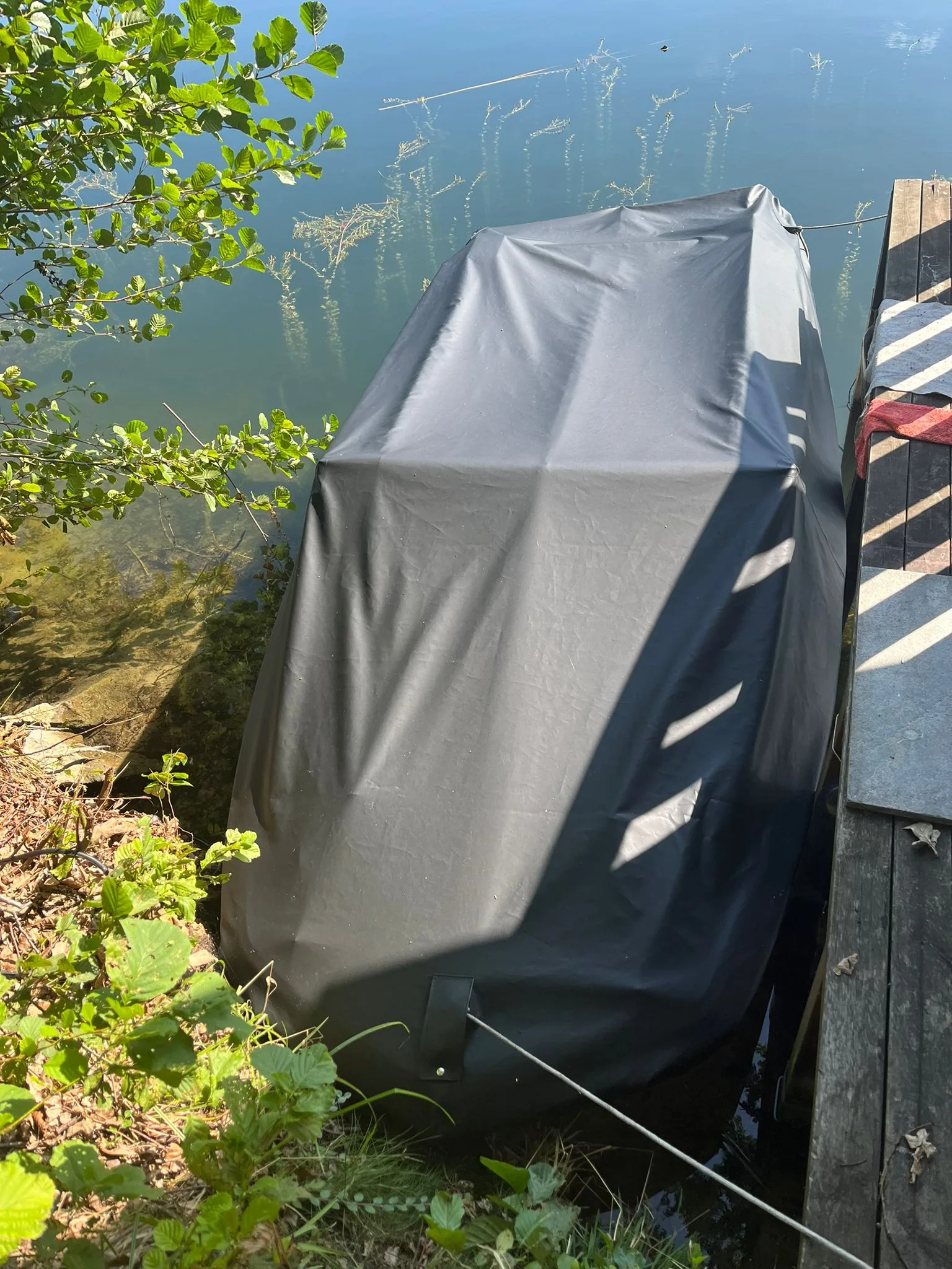 Dunkle Abdeckung über einem abgestellten Boot im Außenbereich.