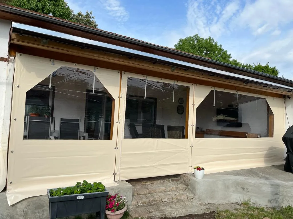 Helle Einhausung mit großen klaren Fensterflächen unter einem Vordach.